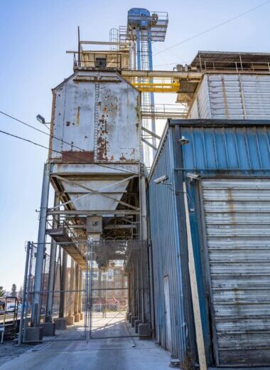 Vertical shot of an aging grain silo in a suburban industrial area